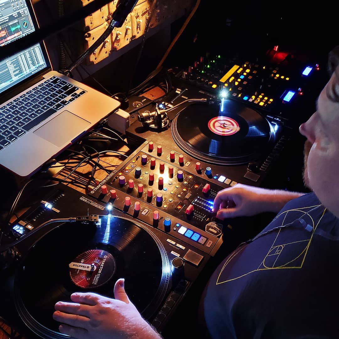 DJ Robzilla mixing on dual Technics turntables with a Traktor laptop setup